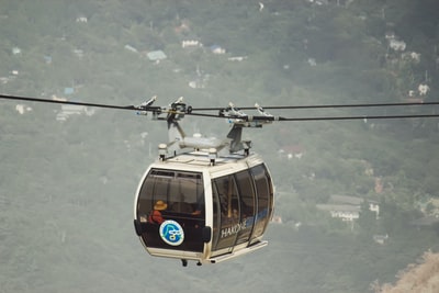 Under the white clouds of black and white cable car during the day
